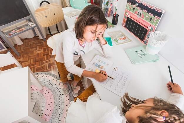 Chica ayudando a la hermana aburrida con la tarea