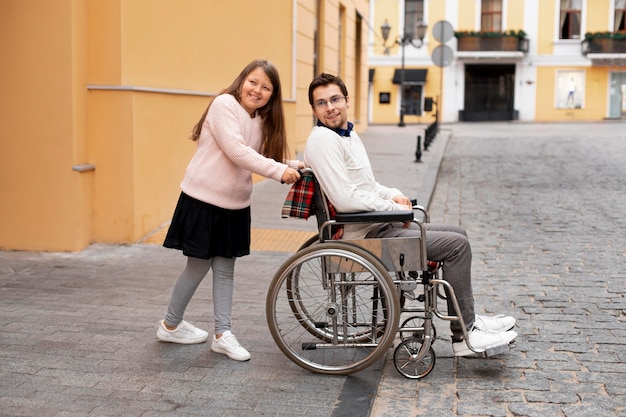 Chica ayudando a hombre discapacitado viajando en la ciudad