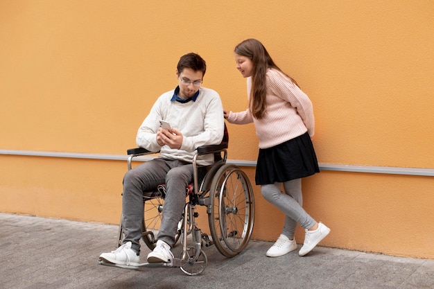 Chica ayudando a hombre discapacitado