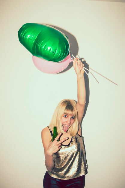 Chica bailando con globos y cerveza