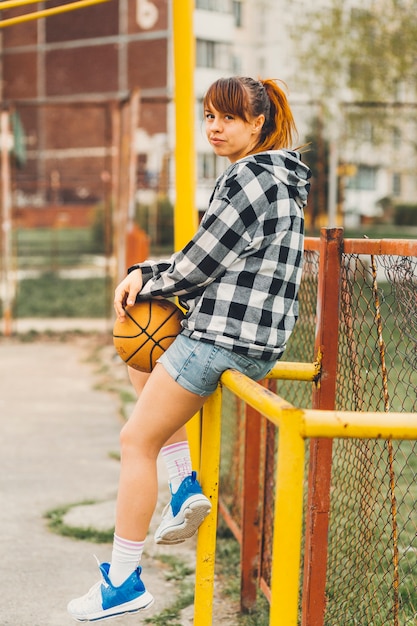 Foto gratuita chica con baloncesto en entorno urbano