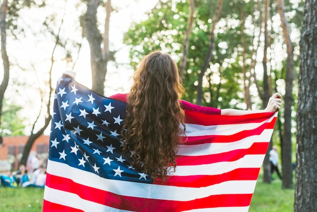 Foto gratuita chica con bandera americana en la naturaleza