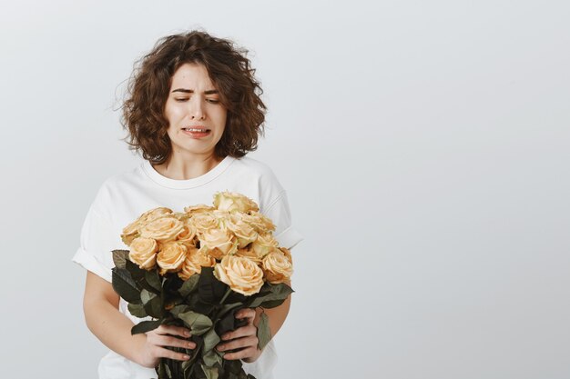 Chica bastante escéptica se encoge al mirar las flores, no le gustan las rosas, no está impresionado