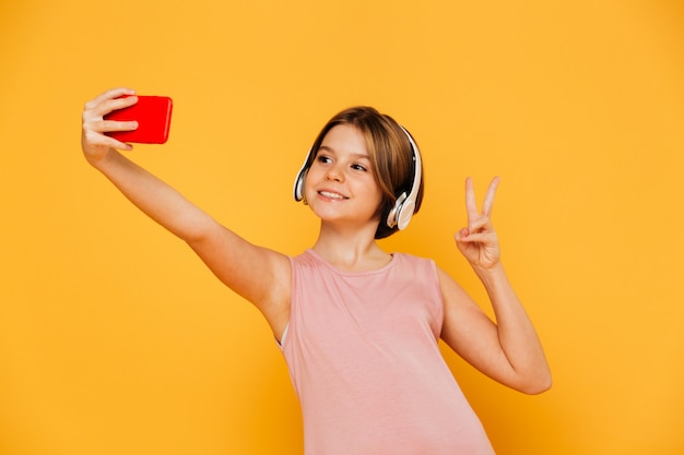 Chica bastante moderna haciendo selfie en smartphone aislado