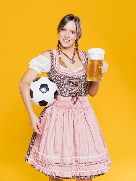 Foto gratuita chica bávara con bola y jarra de cerveza