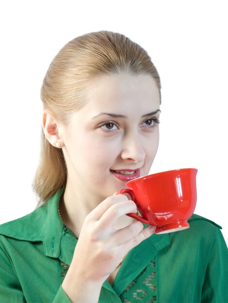 Chica bebe té de una taza roja