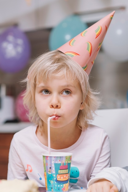 Chica bebiendo en la fiesta de cumpleaños