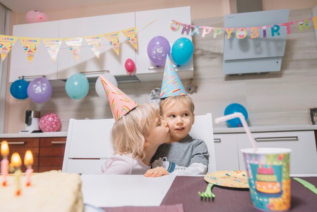 Chica, beso, niño, en, fiesta de cumpleaños