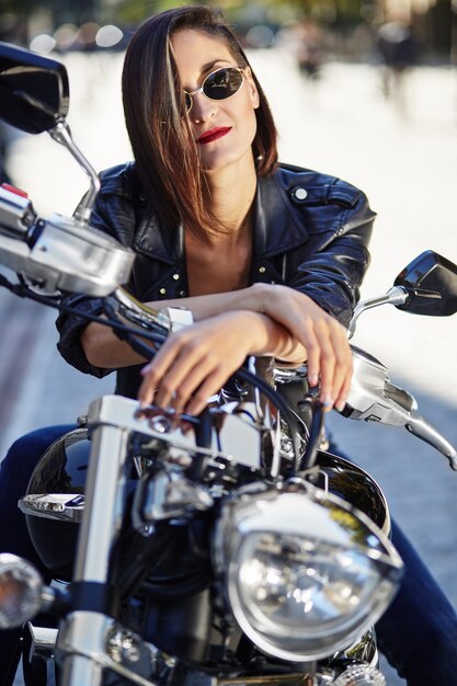 Chica biker en una chaqueta de cuero en moto