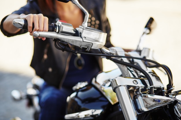 Chica biker en una chaqueta de cuero en moto