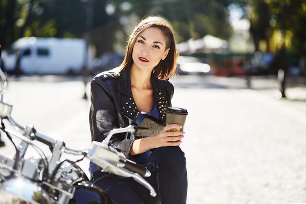 Chica biker en una chaqueta de cuero en moto