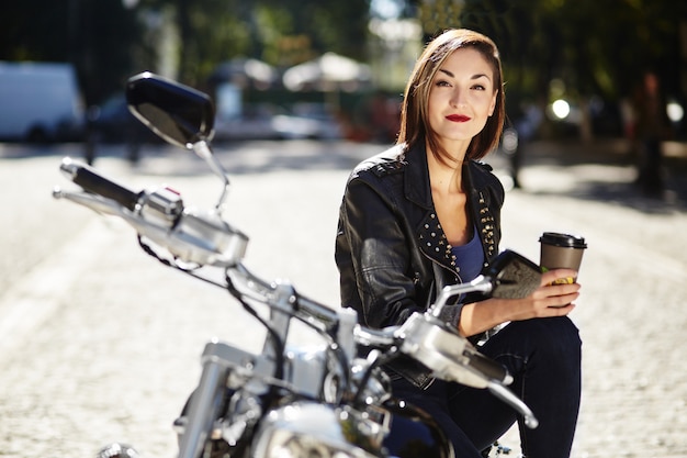 Chica biker en una chaqueta de cuero en moto