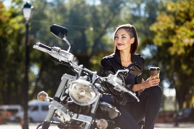 Chica biker en una chaqueta de cuero en moto