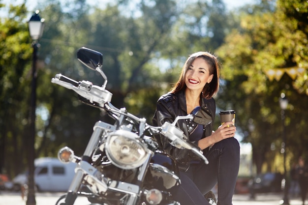 Chica biker en una chaqueta de cuero en moto