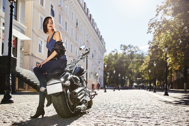 Chica biker en una chaqueta de cuero en moto