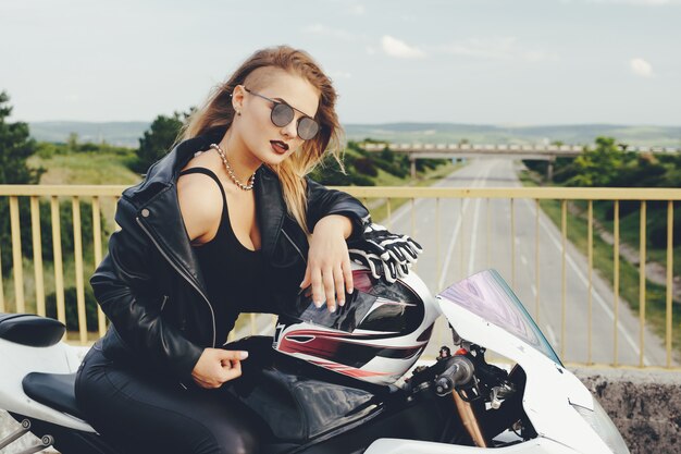 Chica biker en una ropa de cuero en una motocicleta