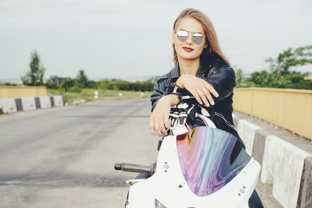 Chica biker en una ropa de cuero en una motocicleta