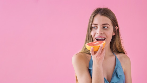 Foto gratuita chica en bikini comiendo pomelo