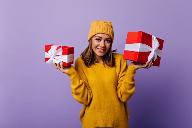 Foto gratuita chica blanca alegre en traje elegante preparando regalos de año nuevo para la familia. retrato interior de hermosa mujer sonriente con regalos.