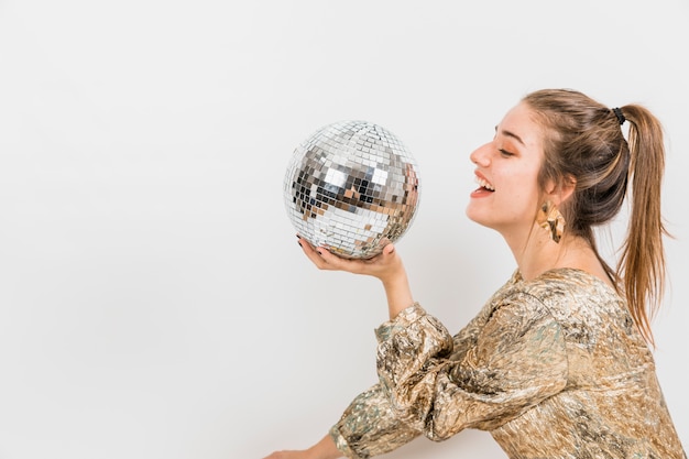 Chica con bola de discoteca en fiesta de año nuevo