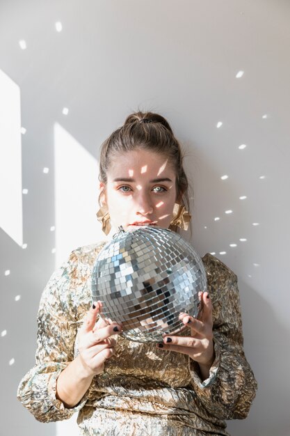 Chica con bola de discoteca en fiesta de año nuevo