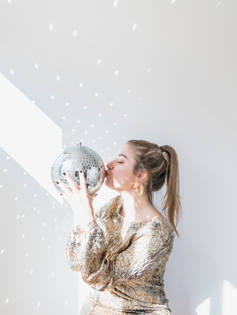 Chica con bola de discoteca en fiesta de año nuevo