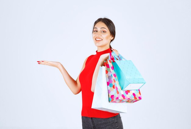 Chica con bolsas de colores sintiéndose positivo.