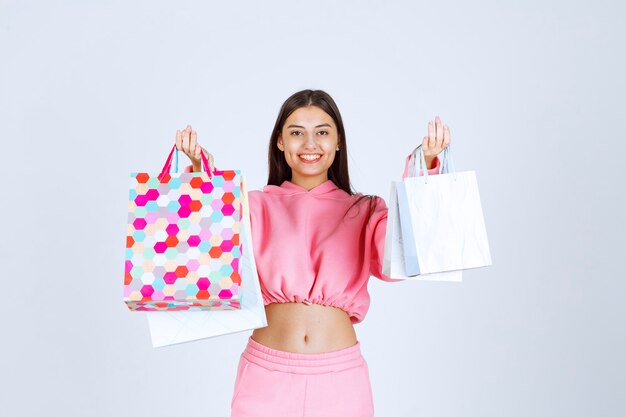 Chica con bolsas de colores se ve feliz y satisfecha.