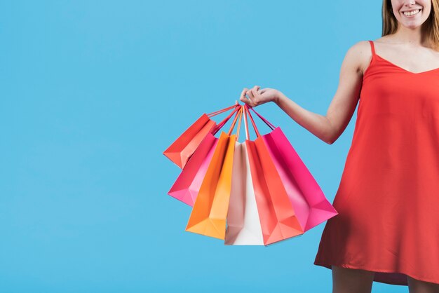 Chica con bolsas de compras en fondo liso