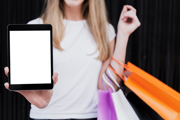 Chica con bolsas de compras con maqueta de tableta