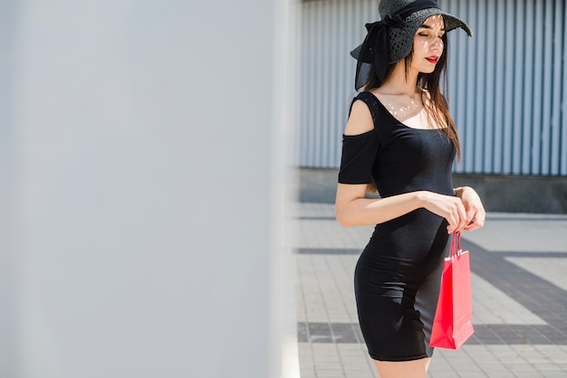 Chica en bolso de la explotación agrícola del vestido negro