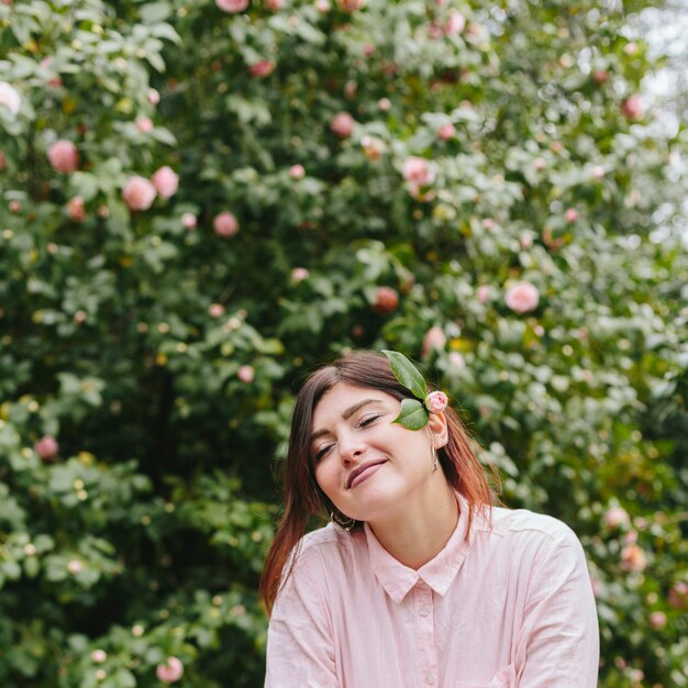 Chica bonita soñadora con flores en el pelo.