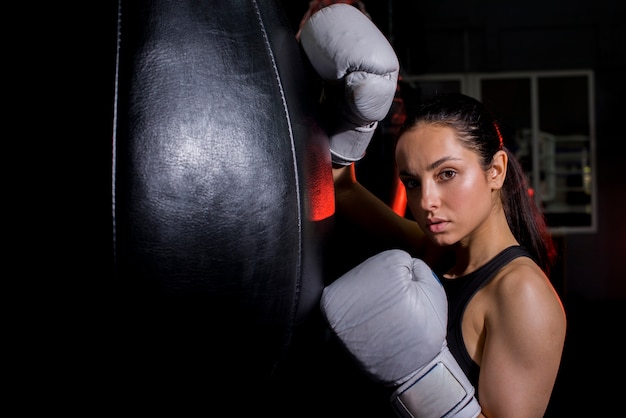 Chica boxeadora posando en el gimnasio