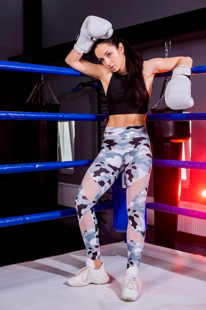 Chica boxeadora posando en el gimnasio