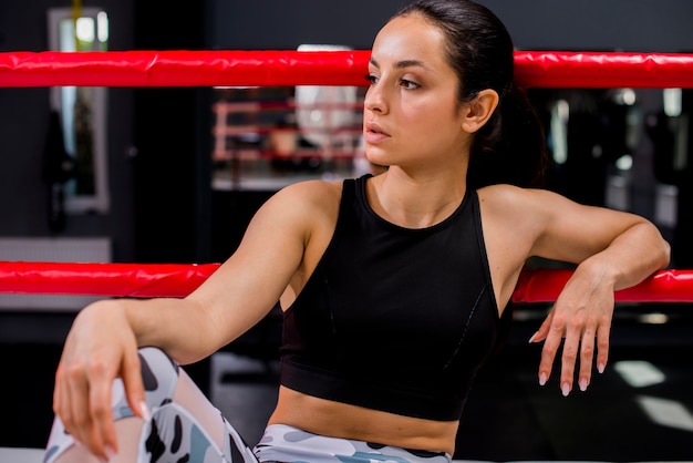 Chica boxeadora posando en el gimnasio