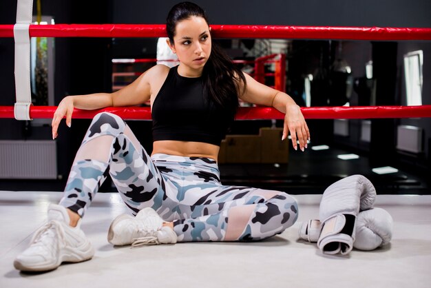 Chica boxeadora posando en el gimnasio