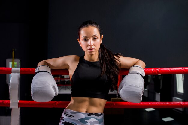 Chica boxeadora posando en el gimnasio