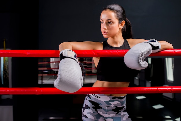 Chica boxeadora posando en el gimnasio