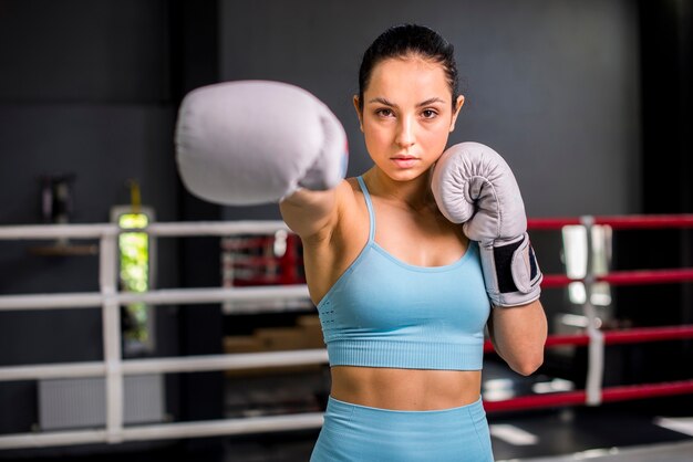 Chica boxeadora posando en el gimnasio