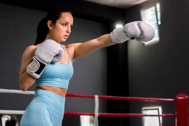 Chica boxeadora posando en el gimnasio