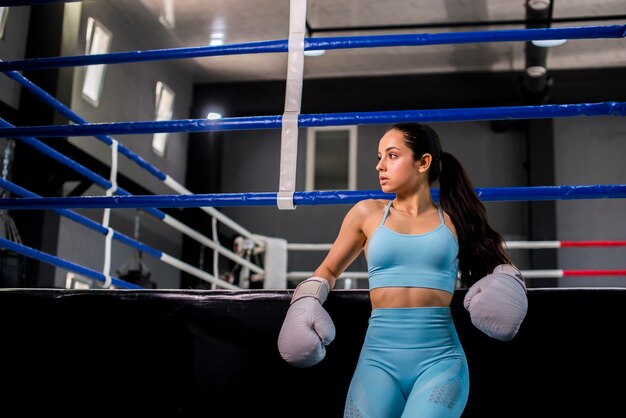 Chica boxeadora posando en el gimnasio