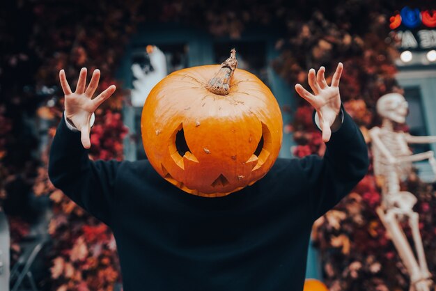 Chica con cabeza de calabaza asusta a la cámara