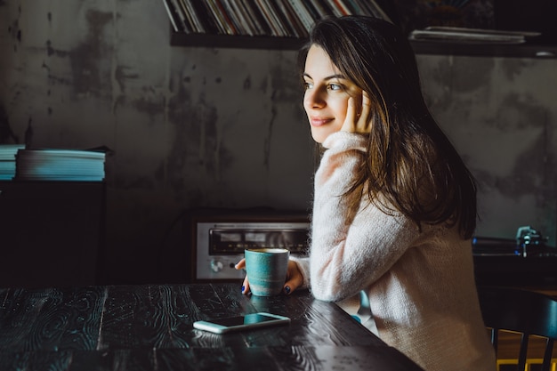 Foto gratuita chica en un café con un teléfono inteligente