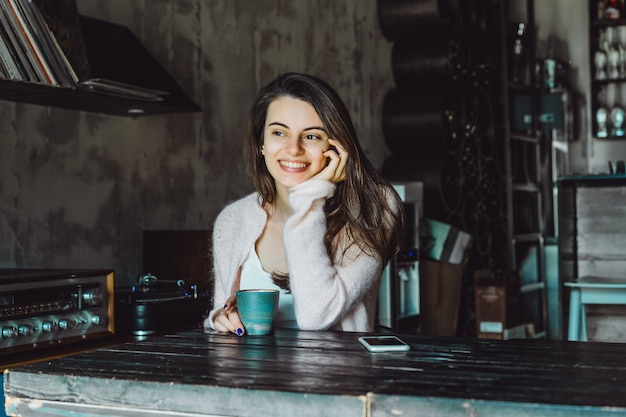 chica en un café con un teléfono inteligente