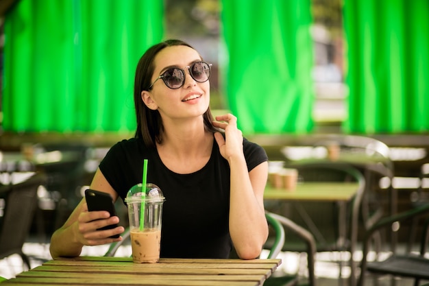 Chica en un café con un teléfono