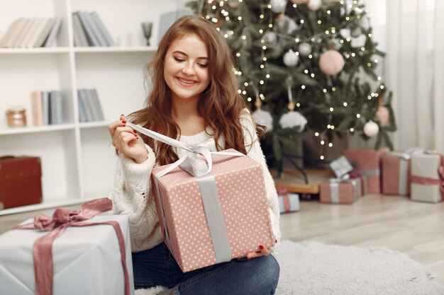 Chica con cajas de Navidad. Mujer en casa. Ladu preparándose para las vacaciones.