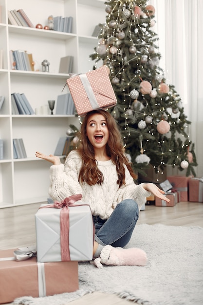 Chica con cajas de Navidad. Mujer en casa. Ladu preparándose para las vacaciones.