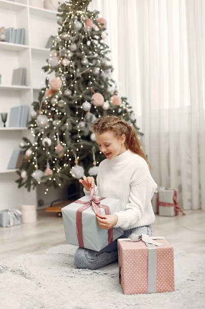 Chica con cajas de Navidad. Mujer en casa. Ladu preparándose para las vacaciones.