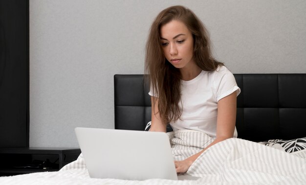 Chica en la cama con laptop