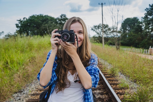Chica con cámara en vías de tren